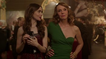 Movie still from “Emily in Paris” (2020), created by Darren Star – Two women standing next to each other at a party; Medium shot, Over the shoulder angle