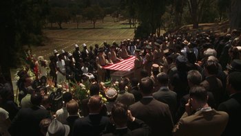 Movie still from “Ghosts of Mississippi” (1996), directed by Rob Reiner – A crowd of people gathered around a flag; Wide shot, High angle