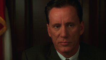 Movie still from “Ghosts of Mississippi” (1996), directed by Rob Reiner – A person wearing a suit and tie; Close Up shot, Low angle