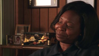 Movie still from “Ghosts of Mississippi” (1996), directed by Rob Reiner – A woman sitting in front of a wooden wall; Close Up shot, Low angle