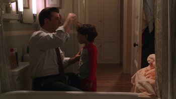 Movie still from “Ghosts of Mississippi” (1996), directed by Rob Reiner – A man and a boy are in a room together; Medium shot, Over the shoulder angle