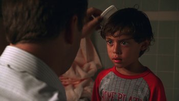 Movie still from “Ghosts of Mississippi” (1996), directed by Rob Reiner – A young boy getting his hair brushed by a man; Close Up shot, Over the shoulder angle