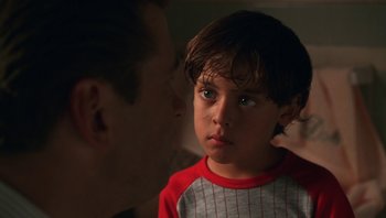 Movie still from “Ghosts of Mississippi” (1996), directed by Rob Reiner – A young boy looking at a man in a red shirt; Close Up shot, Over the shoulder angle