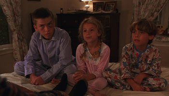 Movie still from “Ghosts of Mississippi” (1996), directed by Rob Reiner – Three children sitting on a bed in their pajamas; Medium shot, High angle