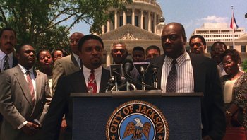 Movie still from “Ghosts of Mississippi” (1996), directed by Rob Reiner – A group of men standing in front of microphones; Medium shot, Low angle