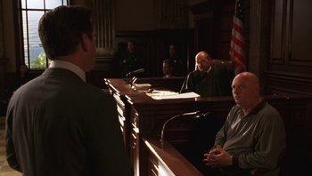 Movie still from “Ghosts of Mississippi” (1996), directed by Rob Reiner – A man in a court room with a judge; Medium shot, Over the shoulder angle