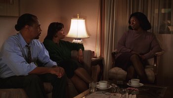 Movie still from “Ghosts of Mississippi” (1996), directed by Rob Reiner – A group of people sitting around a living room table; Medium shot, High angle