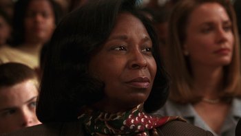 Movie still from “Ghosts of Mississippi” (1996), directed by Rob Reiner – An older woman wearing a colorful scarf looking to her left; Close Up shot, Over the shoulder angle