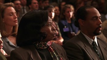 Movie still from “Ghosts of Mississippi” (1996), directed by Rob Reiner – A group of people sitting in front of an audience; Close Up shot, Over the shoulder angle