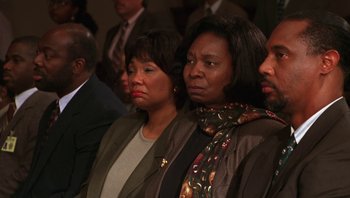 Movie still from “Ghosts of Mississippi” (1996), directed by Rob Reiner – A group of people that are sitting in a room together; Close Up shot, High angle