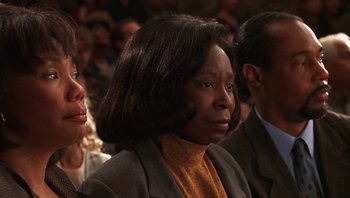 Movie still from “Ghosts of Mississippi” (1996), directed by Rob Reiner – An older woman is sitting in a crowd of people; Close Up shot, High angle