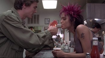 Movie still from “Gia” (1998), directed by Michael Cristofer – A man and a woman sitting at a table; Medium shot, Over the shoulder angle