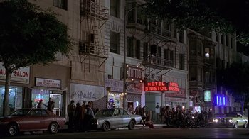 Movie still from “Gia” (1998), directed by Michael Cristofer – A group of people standing on the side of a building; Extreme Wide shot, High angle