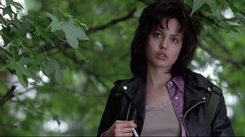 Movie still from “Gia” (1998), directed by Michael Cristofer – A woman in a leather jacket holding a cell phone in her hand; Close Up shot, Over the shoulder angle