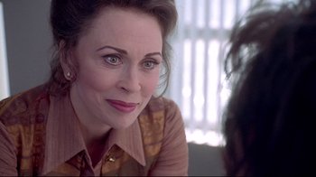 Movie still from “Gia” (1998), directed by Michael Cristofer – A person sitting down looking at the camera; Close Up shot, Over the shoulder angle