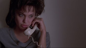 Movie still from “Gia” (1998), directed by Michael Cristofer – A woman holding a phone to her ear; Close Up shot, High angle