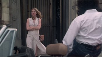 Movie still from “Gia” (1998), directed by Michael Cristofer – A beautiful woman standing next to a building; Medium shot, Over the shoulder angle