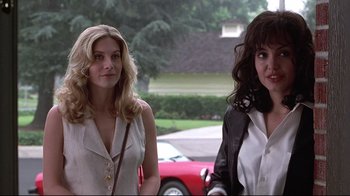 Movie still from “Gia” (1998), directed by Michael Cristofer – Two women walking down the street in front of a red car; Close Up shot, Over the shoulder angle