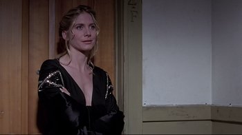 Movie still from “Gia” (1998), directed by Michael Cristofer – A woman standing in front of a wall with her arms crossed; Close Up shot, Low angle