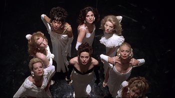 Movie still from “Gia” (1998), directed by Michael Cristofer – A group of women in white dresses and gloves posing; Wide shot, Overhead angle