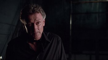 Movie still from “Gia” (1998), directed by Michael Cristofer – An older man smoking a cigarette while wearing a black shirt; Close Up shot, Low angle