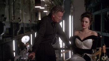 Movie still from “Gia” (1998), directed by Michael Cristofer – A man and a woman are talking to each other; Medium shot, Over the shoulder angle