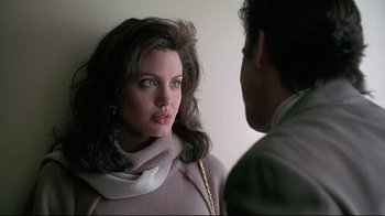 Movie still from “Gia” (1998), directed by Michael Cristofer – A woman wearing a scarf looking at a man in a suit; Close Up shot, Over the shoulder angle