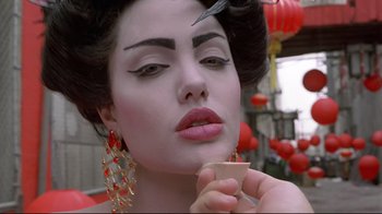 Movie still from “Gia” (1998), directed by Michael Cristofer – A beautiful woman with a large pair of scissors in her mouth; Close Up shot, Over the shoulder angle