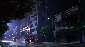 Movie still from “Gia” (1998), directed by Michael Cristofer – A car driving down a street at night; Extreme Wide shot, Low angle