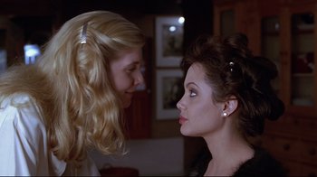 Movie still from “Gia” (1998), directed by Michael Cristofer – Two women looking at one another in a room; Close Up shot, Over the shoulder angle