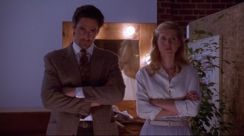 Movie still from “Gia” (1998), directed by Michael Cristofer – A man and a woman standing next to each other in front of a mirror; Medium shot, Low angle