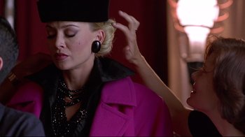 Movie still from “Gia” (1998), directed by Michael Cristofer – A woman in a black hat and a pink jacket; Close Up shot, Over the shoulder angle