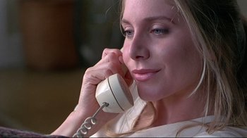 Movie still from “Gia” (1998), directed by Michael Cristofer – A beautiful woman holding a phone up to her ear; Close Up shot, High angle