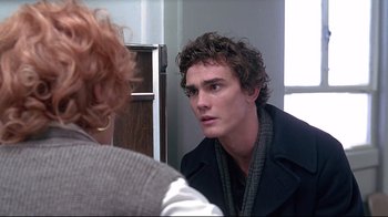 Movie still from “Gia” (1998), directed by Michael Cristofer – A man looking into a mirror while standing next to a woman; Close Up shot, Over the shoulder angle