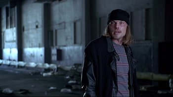 Movie still from “Gia” (1998), directed by Michael Cristofer – A man standing in an abandoned building wearing a hat; Medium shot, Low angle
