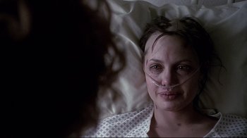 Movie still from “Gia” (1998), directed by Michael Cristofer – A woman laying in a bed with her eyes open; Close Up shot, Over the shoulder angle