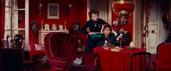 Movie still from “Gigi” (1958), directed by Vincente Minnelli – Two women in a room with a cat sitting on a chair; Medium shot, High angle