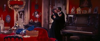 Movie still from “Gigi” (1958), directed by Vincente Minnelli – A man and a woman kissing in front of a piano; Wide shot, High angle