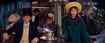 Movie still from “Gigi” (1958), directed by Vincente Minnelli – A group of people sitting at a table with a drink; Medium shot, Over the shoulder angle