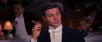 Movie still from “Gigi” (1958), directed by Vincente Minnelli – A man in a tuxedo holding a cigar in his right hand; Close Up shot, High angle