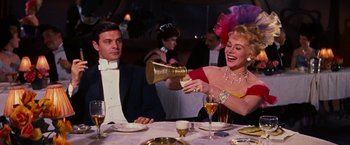 Movie still from “Gigi” (1958), directed by Vincente Minnelli – A man and a woman sitting at a dinner table; Medium shot, Over the shoulder angle