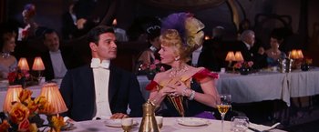 Movie still from “Gigi” (1958), directed by Vincente Minnelli – A man and a woman sitting at a dinner table; Medium shot, Over the shoulder angle