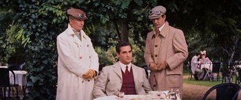 Movie still from “Gigi” (1958), directed by Vincente Minnelli – A man sitting in front of two other men; Medium shot, Over the shoulder angle