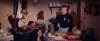 Movie still from “Gigi” (1958), directed by Vincente Minnelli – A man and a woman preparing food in a kitchen; Medium shot, Over the shoulder angle