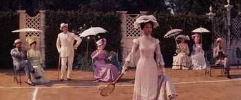 Movie still from “Gigi” (1958), directed by Vincente Minnelli – A group of people dressed in period clothing; Wide shot, High angle