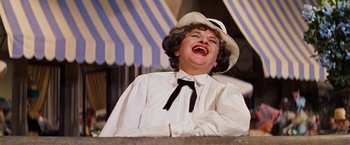 Movie still from “Gigi” (1958), directed by Vincente Minnelli – A woman in a white shirt and a white hat laughing; Close Up shot, Low angle