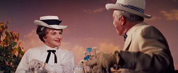 Movie still from “Gigi” (1958), directed by Vincente Minnelli – An older man and woman sitting at a table; Medium shot, Over the shoulder angle