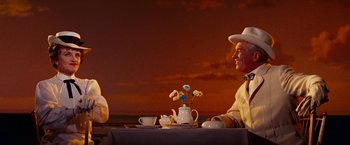 Movie still from “Gigi” (1958), directed by Vincente Minnelli – A man sitting at a table with a teapot and a cup; Medium shot, Low angle