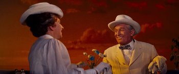 Movie still from “Gigi” (1958), directed by Vincente Minnelli – A man in a white suit and a man in a white hat holding flowers; Medium shot, Over the shoulder angle