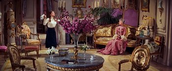 Movie still from “Gigi” (1958), directed by Vincente Minnelli – Two women sitting in a living room next to each other; Wide shot, High angle
